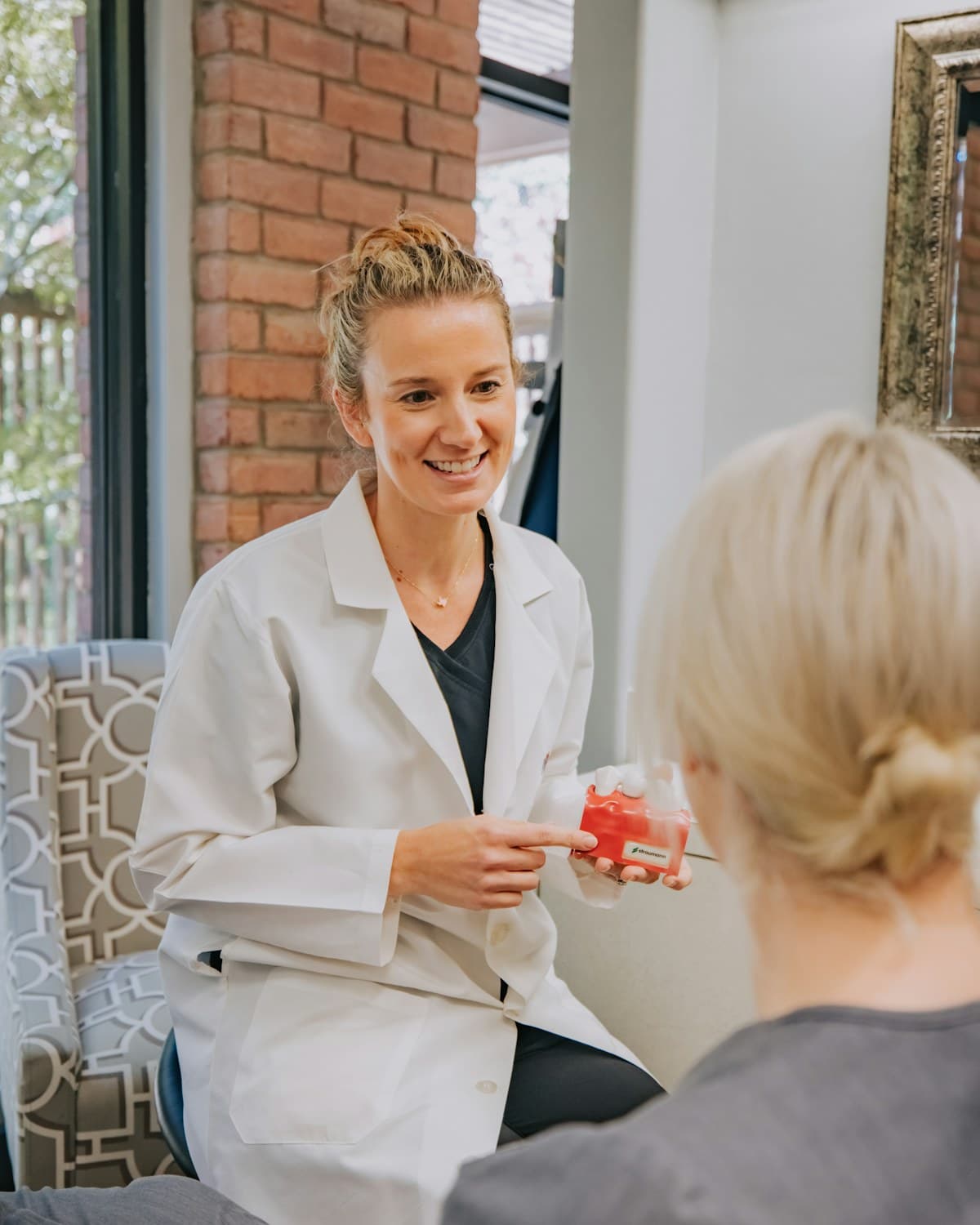 A Marloe Dental dentist explaining a treatment to a patient using a study model